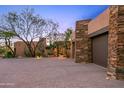 Spacious three-car garage with stone accents and a paved driveway at 40980 N 97Th St, Scottsdale, AZ 85262