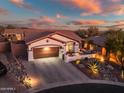 Single story home with desert landscaping and two car garage at dusk at 41240 N Shadow Creek Ct, Anthem, AZ 85086