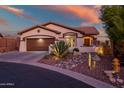 Single-story home with desert landscaping and two-car garage at sunset at 41240 N Shadow Creek Ct, Anthem, AZ 85086