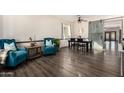 Dining area with teal armchairs, barn door, and dark wood table at 43244 N Heavenly Way, Anthem, AZ 85086