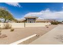 Front view of a tan house with large windows and a landscaped yard at 6210 E Mallory St, Mesa, AZ 85215