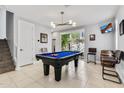 Bright game room with a blue billiard table, stylish light fixture, and natural light from the large window at 6850 E Mcdowell Rd # 72, Scottsdale, AZ 85257