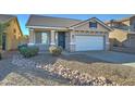 House exterior showcasing a two-car garage and rock landscaping at 7037 W Pontiac Dr, Glendale, AZ 85308