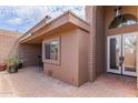 Covered porch with brick flooring, views to the yard and a beveled glass front door at 7770 E Camelback Rd # 16, Scottsdale, AZ 85251