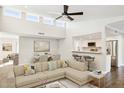 Open living room features hardwood floors, a sectional sofa, and a view into the kitchen at 9412 N 33Rd Way, Phoenix, AZ 85028