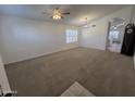 Spacious living room featuring plush carpeting, a ceiling fan, and great natural lighting at 10245 W Jessie Ln, Peoria, AZ 85383