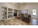 Living room with built-in shelving and a large TV at 11246 W Chase Dr, Avondale, AZ 85323