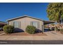 Tan single-wide manufactured home with carport and landscaping at 11275 N 99Th Ave # 188, Peoria, AZ 85345