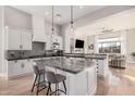 Gourmet kitchen boasts granite island and white cabinetry at 1211 W Sousa Ct, Anthem, AZ 85086