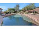 Inviting pool with a waterfall feature and desert landscaping at 12238 E Poinsettia Dr, Scottsdale, AZ 85259