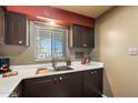 Kitchen features dark cabinets, white countertops and a window at 131 N Higley Rd # 213, Mesa, AZ 85205