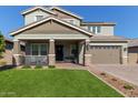 Two-story house with a green lawn, two-car garage, and front porch at 15130 W Linden St, Goodyear, AZ 85338