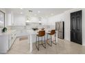 Modern white kitchen with a large island, stainless steel appliances, and gold accents at 2128 E Leo Pl, Chandler, AZ 85249