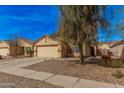 Tan single-story home with a well-manicured front yard and attached two-car garage in a quiet neighborhood at 2172 W Pinkley Ave, Coolidge, AZ 85128