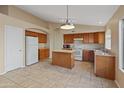 Open kitchen with wood cabinets and a center island at 2805 N 111Th Dr, Avondale, AZ 85392