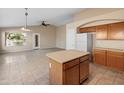 Kitchen features island, tile floors, and wooden cabinets at 2805 N 111Th Dr, Avondale, AZ 85392