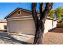 Tan house with a two-car garage and desert landscaping at 34717 N Picket Post Dr, Queen Creek, AZ 85142