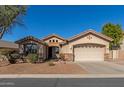 Tan house with a two-car garage and drought-tolerant landscaping at 7432 E Melrose St, Mesa, AZ 85207