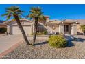 Tan two-story house with a two-car garage and palm trees at 8732 W Rockwood Dr, Peoria, AZ 85382