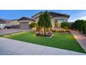 Landscaped front yard with artificial turf and a welcoming walkway to the entrance of the home at 9343 W Cashman Dr, Peoria, AZ 85383