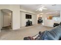 Spacious living room with neutral carpet, a ceiling fan, and an open floor plan at 15144 W Washington St, Goodyear, AZ 85338