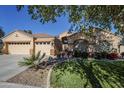 House exterior with a three-car garage and landscaping at 16364 W Roosevelt St, Goodyear, AZ 85338