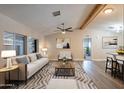 Bright living room features hardwood floors, neutral walls, and a comfortable sofa at 3710 W Irma Ln, Glendale, AZ 85308