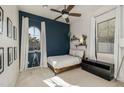 Bedroom with a blue accent wall and an arched window with white curtains at 4747 S Aileron Ln, Mesa, AZ 85212