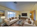 Living room with light beige couches and a large TV at 816 S Esperanza Ave, Mesa, AZ 85208