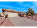 Tan house with a two-car garage and desert landscaping at 8450 W Rose Pilar Ct, Peoria, AZ 85382