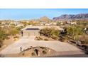 Aerial view of a stunning home with solar panels, a large driveway, and mountain views at 10400 E Breathless Ave, Gold Canyon, AZ 85118