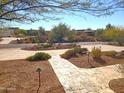 Landscaped front yard with stone pathway, mature trees, and desert landscaping at 10400 E Breathless Ave, Gold Canyon, AZ 85118