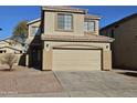 Two-story house with tan exterior, two-car garage, and landscaping at 11410 W Cocopah St, Avondale, AZ 85323