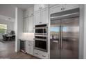 Modern kitchen with double ovens, wine fridge, and white cabinetry at 14840 E Valley Vista Dr, Fountain Hills, AZ 85268