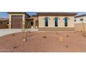 Tan three-bedroom house with a two-car garage and arched windows at 17330 W Royal Palm Rd, Waddell, AZ 85355