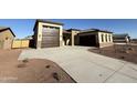 New construction home with a two-car garage and desert landscaping at 17330 W Royal Palm Rd, Waddell, AZ 85355