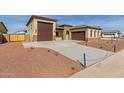 New home exterior featuring a three-car garage and desert landscaping at 17330 W Royal Palm Rd, Waddell, AZ 85355