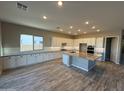 Modern kitchen with white cabinets, grey island, and wood-look tile floors at 17330 W Royal Palm Rd, Waddell, AZ 85355