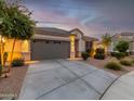 One-story home with gray garage door, landscaping, and a welcoming front porch at 18280 N Piccolo Dr, Maricopa, AZ 85138