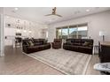 Spacious living room with leather sofas, a large window, and view into kitchen at 19651 W Monterey Way, Buckeye, AZ 85396