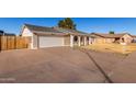 Front view of a single-story home with a white garage door at 2618 W Surrey Ave, Phoenix, AZ 85029