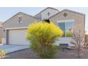 Light brown house with a two-car garage and flowering bushes at 30905 W Fairmount Ave, Buckeye, AZ 85396