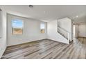 Spacious living room with wood-look floors and staircase at 37536 W Patterson St, Maricopa, AZ 85138