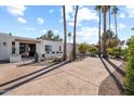 Landscaped front yard with palm trees and a long driveway leading to the house at 4437 N Granite Reef Rd, Scottsdale, AZ 85251