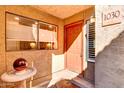 Front entry with orange door, sidelights, and a birdbath at 5122 E Shea Blvd # 1030, Scottsdale, AZ 85254