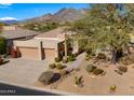 Tan colored house with a two-car garage and mountain views at 6358 E Evening Glow Dr, Scottsdale, AZ 85266