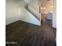 Living room with hardwood floors, staircase, and kitchen view at 7827 W Cypress St, Phoenix, AZ 85035