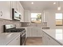 Bright kitchen with stainless appliances, white cabinets and a view from the window at 8333 N 54Th Ln, Glendale, AZ 85302