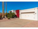 White stucco single story home with attached two car garage and red flowering bushes at 8602 E San Alfredo Dr, Scottsdale, AZ 85258