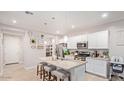 Modern kitchen with granite countertops and white cabinets at 17536 W Desert Bloom St, Goodyear, AZ 85338